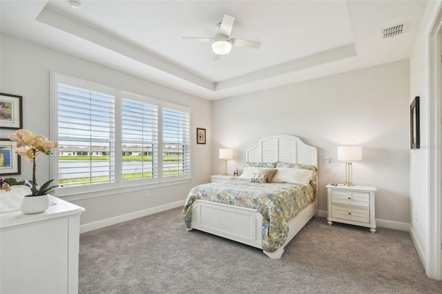 bedroom featuring a tray ceiling, ceiling fan, and light colored carpet