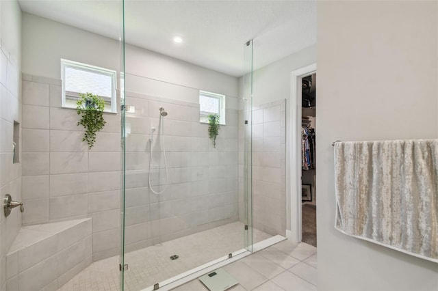 bathroom with tile patterned flooring, a healthy amount of sunlight, and walk in shower