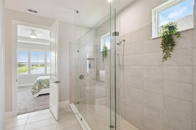 bathroom with a shower with door, ceiling fan, and tile patterned floors