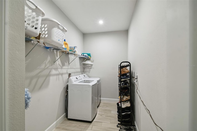 clothes washing area with light hardwood / wood-style floors and washing machine and dryer