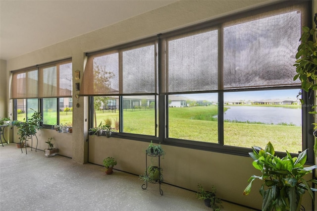 unfurnished sunroom featuring a water view