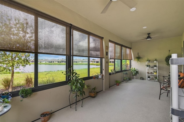 unfurnished sunroom with a water view and ceiling fan