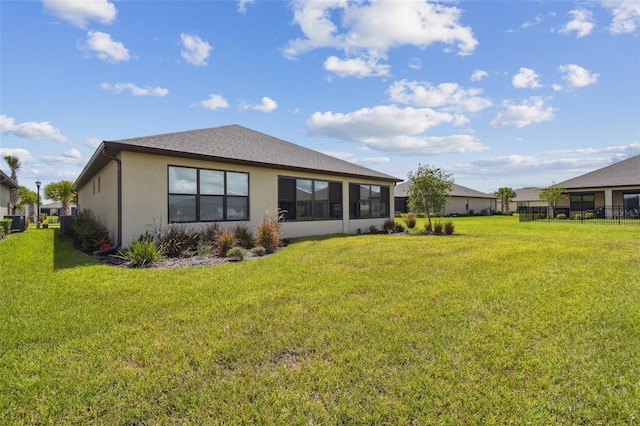 back of house featuring a yard and a sunroom