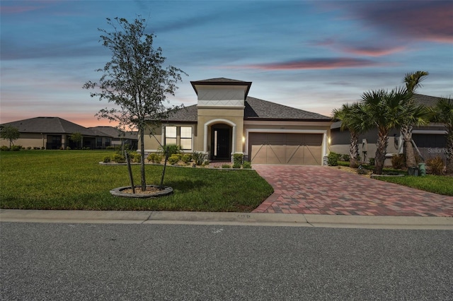 view of front facade featuring a garage and a lawn