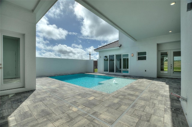 view of swimming pool with a patio and french doors