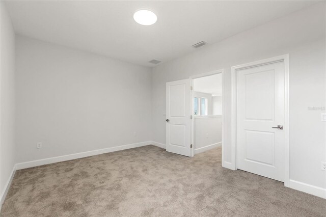 unfurnished room featuring light colored carpet