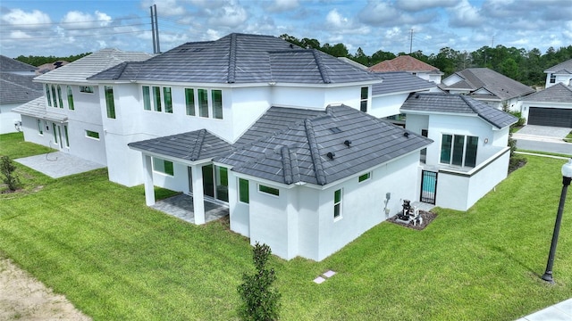 back of house featuring a patio area and a lawn