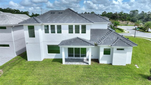 rear view of property featuring a yard and a patio