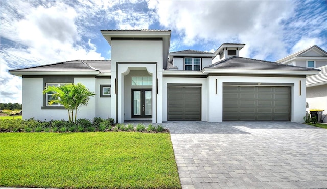 107 Hampton Loop, Davenport, FL 33837 - view of front facade featuring french doors, stucco siding, decorative driveway, a front yard, and an attached garage