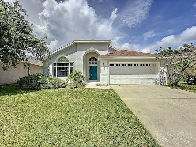 mediterranean / spanish-style house featuring a front lawn and a garage