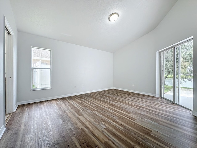 unfurnished room with baseboards, dark wood-type flooring, and a textured ceiling