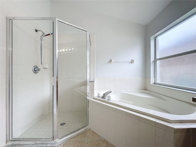 full bath with tile patterned floors, a bath, and a stall shower