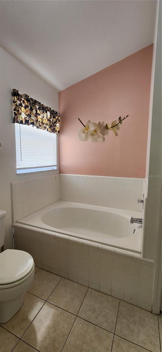 bathroom featuring toilet, tiled tub, and tile patterned floors