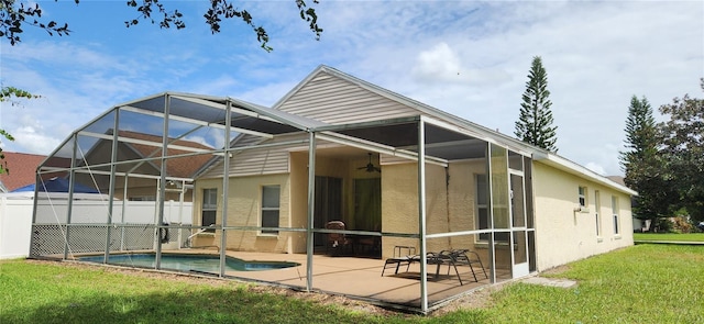 rear view of house featuring a fenced in pool, a lanai, a yard, and a patio