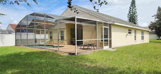 back of property with glass enclosure, a fenced in pool, a lawn, and a patio