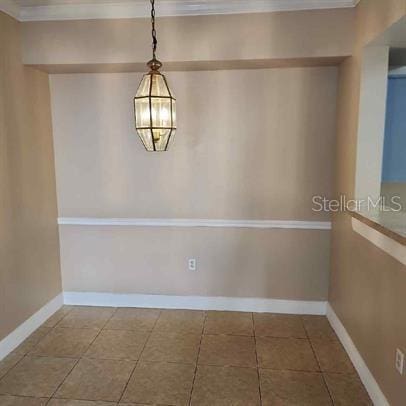 tiled spare room with crown molding