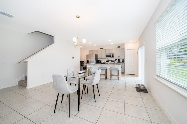 tiled dining space featuring an inviting chandelier