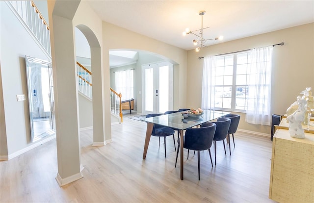 dining area with an inviting chandelier and light hardwood / wood-style flooring