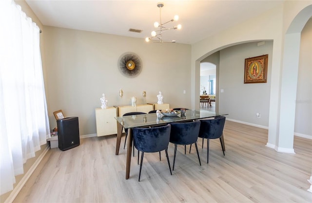 dining area featuring light hardwood / wood-style flooring and a notable chandelier