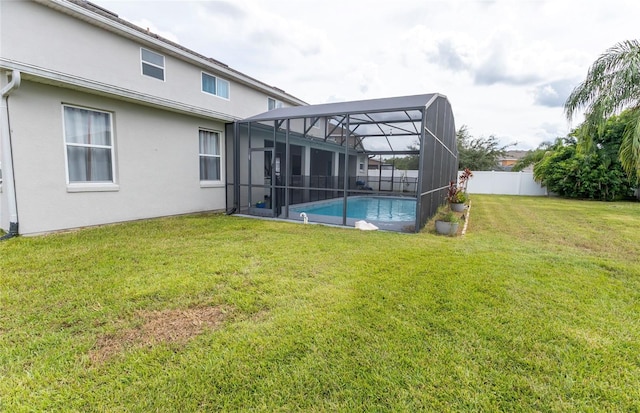 view of yard with glass enclosure and a fenced in pool