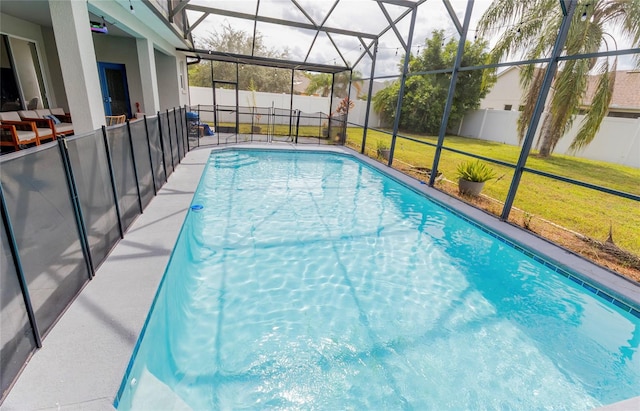 view of pool with a lawn, a patio area, and glass enclosure