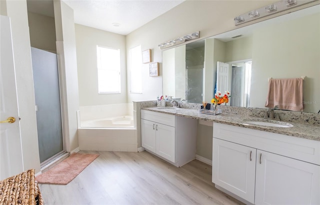 bathroom with vanity, plus walk in shower, and hardwood / wood-style flooring