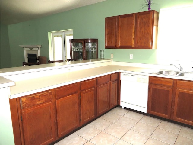 kitchen featuring light tile patterned floors, kitchen peninsula, white dishwasher, and sink