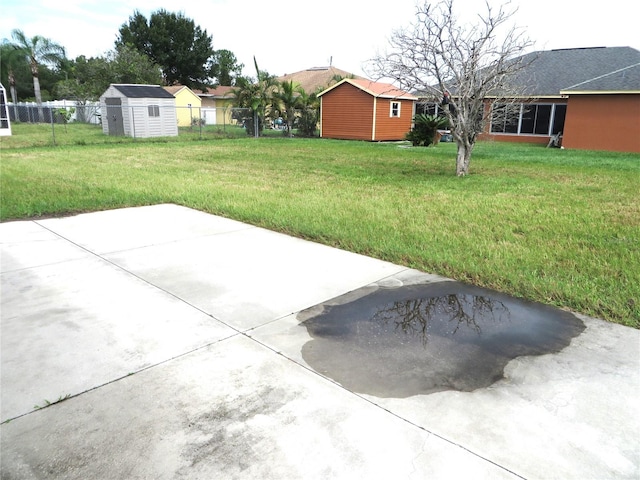 view of yard featuring a storage unit and a patio