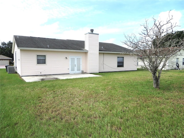 rear view of property with french doors, a patio area, a lawn, and central air condition unit