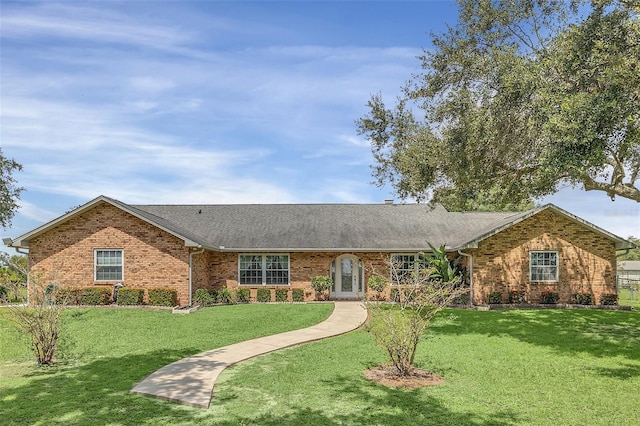 4147 Boggy Creek Rd, Kissimmee, FL 34744 - ranch-style house featuring brick siding, a front lawn, and roof with shingles