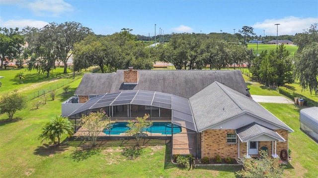 view of swimming pool featuring a yard and a lanai