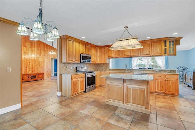 4147 Boggy Creek Rd, Kissimmee, FL 34744 - kitchen featuring stainless steel appliances, a kitchen island, a chandelier, decorative backsplash, and crown molding