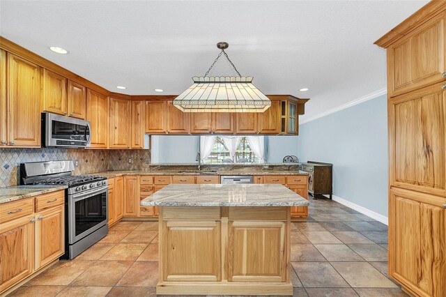 4147 Boggy Creek Rd, Kissimmee, FL 34744 - kitchen featuring stainless steel appliances, crown molding, baseboards, a center island, and backsplash