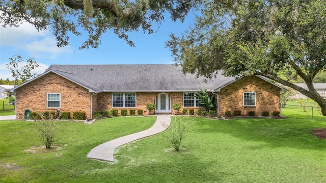 4147 Boggy Creek Rd, Kissimmee, FL 34744 - ranch-style home featuring brick siding, a front lawn, and a shingled roof