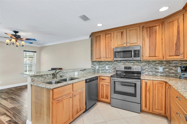 4147 Boggy Creek Rd, Kissimmee, FL 34744 - kitchen featuring appliances with stainless steel finishes, a sink, a peninsula, ornamental molding, and tasteful backsplash