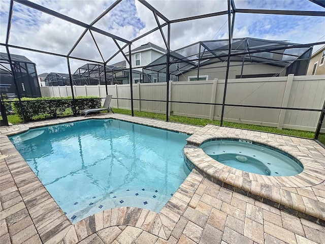 view of pool with a lanai and an in ground hot tub