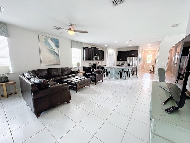 living room with light tile patterned floors, visible vents, a ceiling fan, and recessed lighting