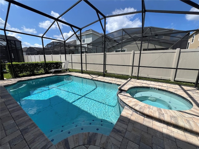 view of pool featuring glass enclosure, a pool with connected hot tub, and fence