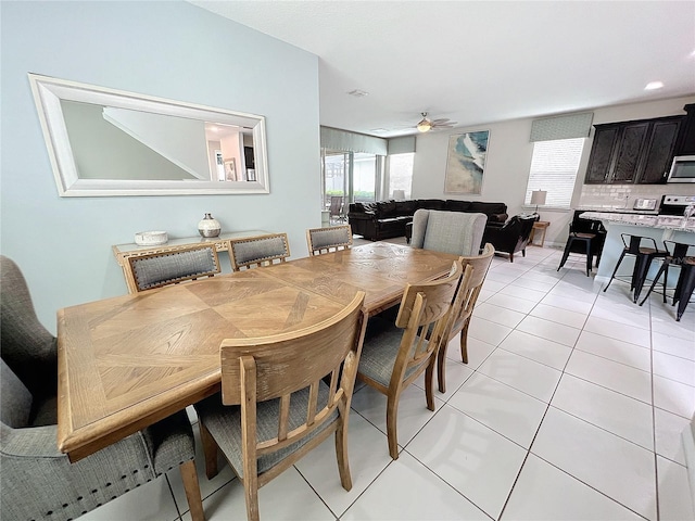 dining area featuring a ceiling fan, light tile patterned floors, and a healthy amount of sunlight