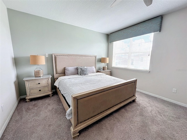 bedroom featuring carpet, baseboards, and a textured ceiling