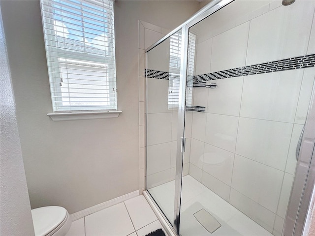 full bathroom featuring a shower stall, toilet, baseboards, and tile patterned floors