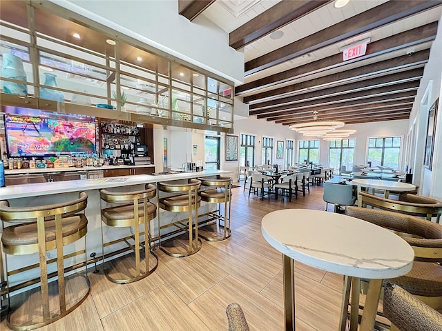 bar featuring beam ceiling, a dry bar, and high vaulted ceiling