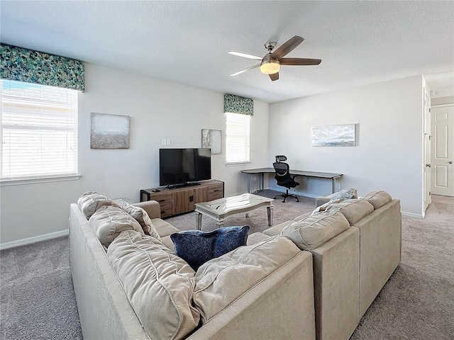 carpeted living area with baseboards, a textured ceiling, and a ceiling fan