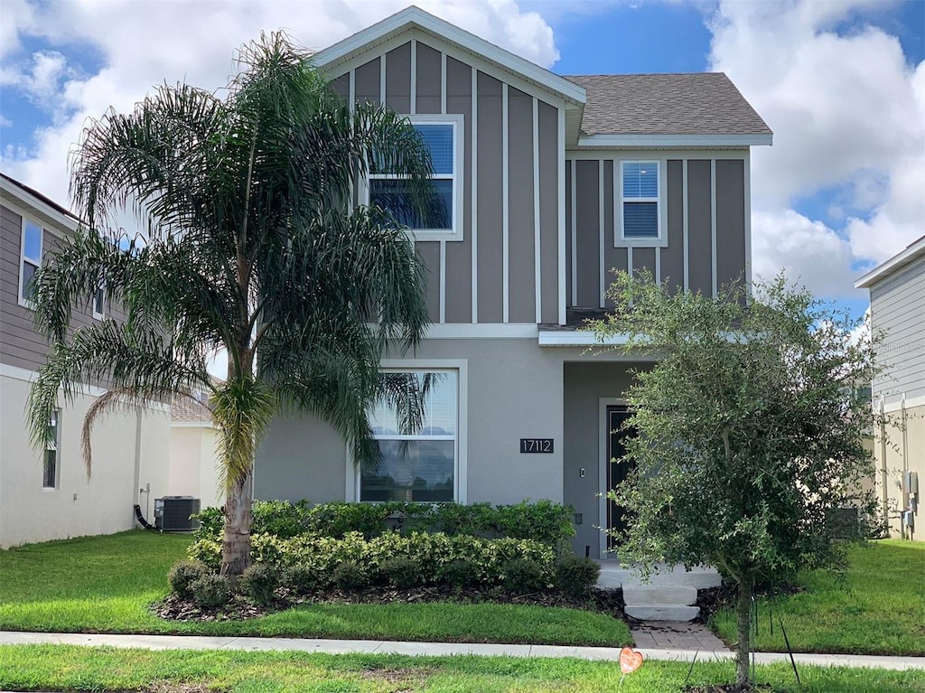 view of front of home featuring cooling unit and a front lawn