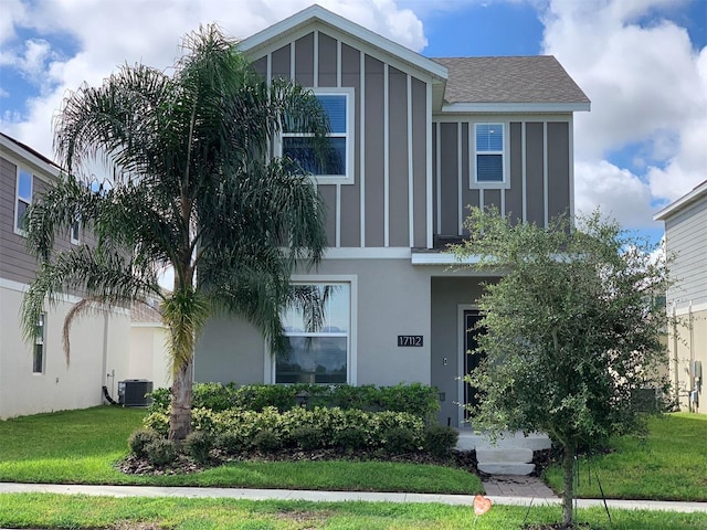 view of front of home featuring cooling unit and a front lawn