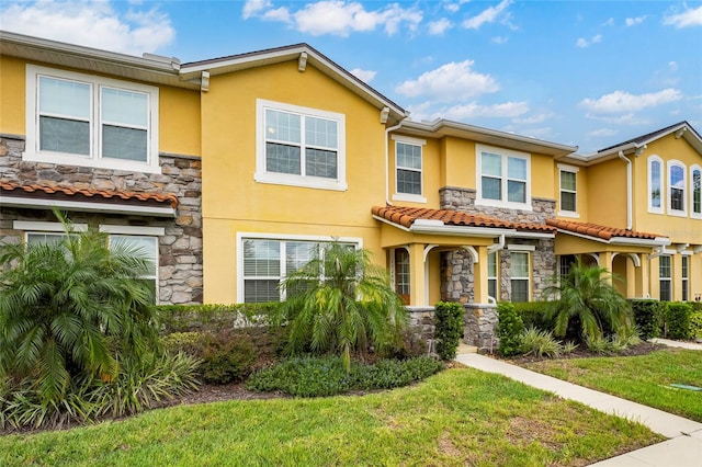 townhome / multi-family property featuring a front yard