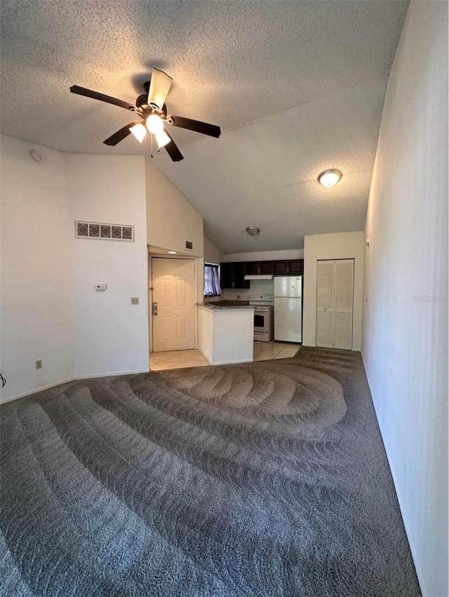 unfurnished living room with lofted ceiling, ceiling fan, carpet, and a textured ceiling