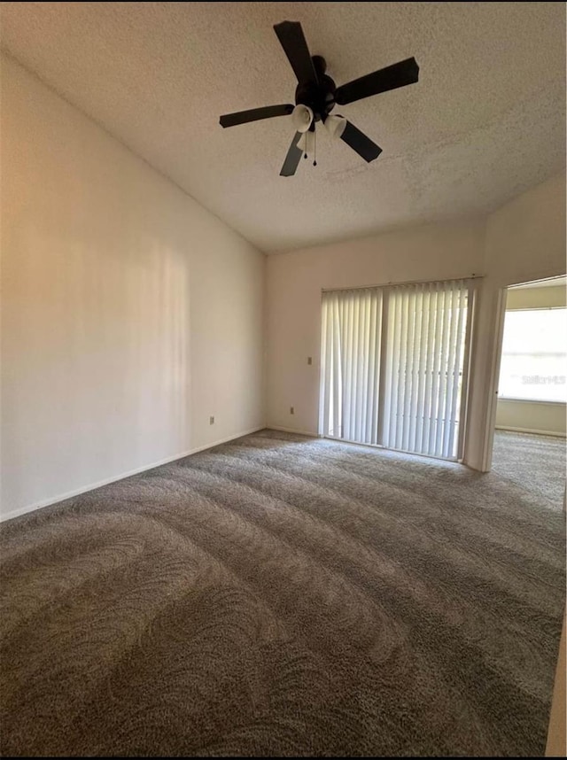 unfurnished room featuring lofted ceiling, a textured ceiling, ceiling fan, and carpet