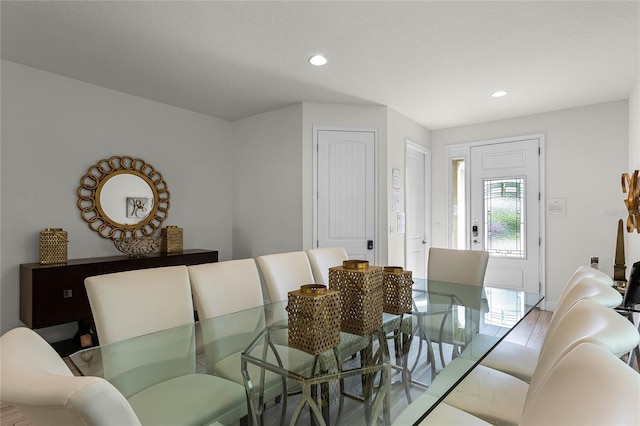 dining space with a textured ceiling and light hardwood / wood-style flooring