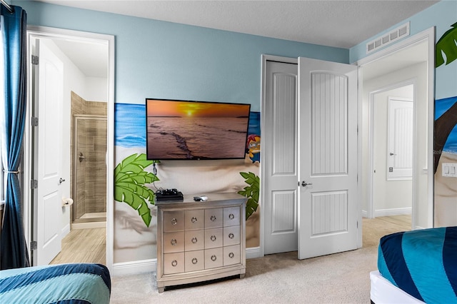 bedroom featuring a textured ceiling and light colored carpet